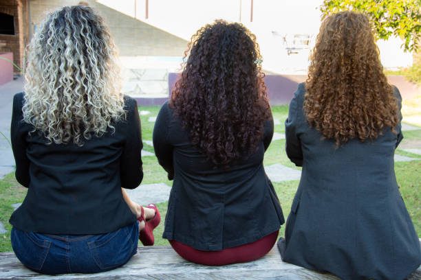 three curly haired women wearing blazer