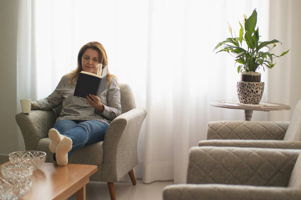 photo of a woman reading a book at home. photo of a woman reading a book at home.